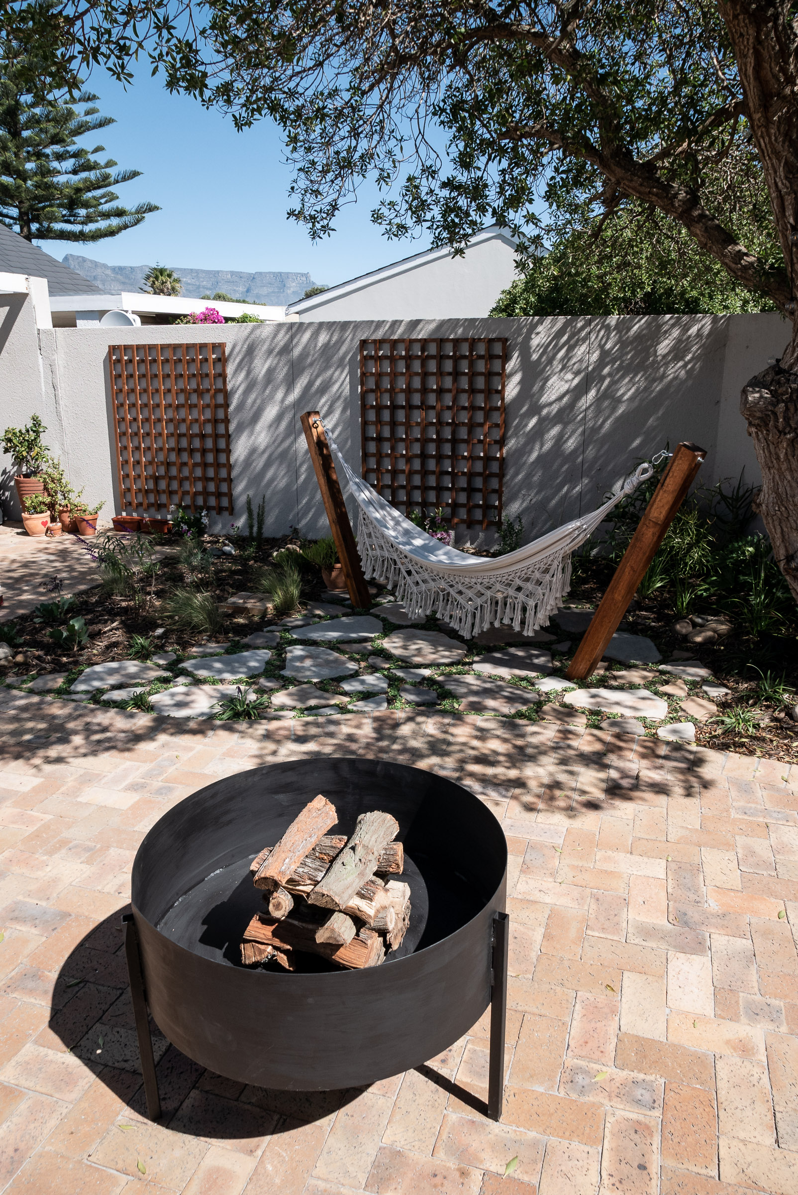 horizon-paving-hammock-area-and-fire-pit-clay-pavers Patio with hammack below tree and steel fire pit